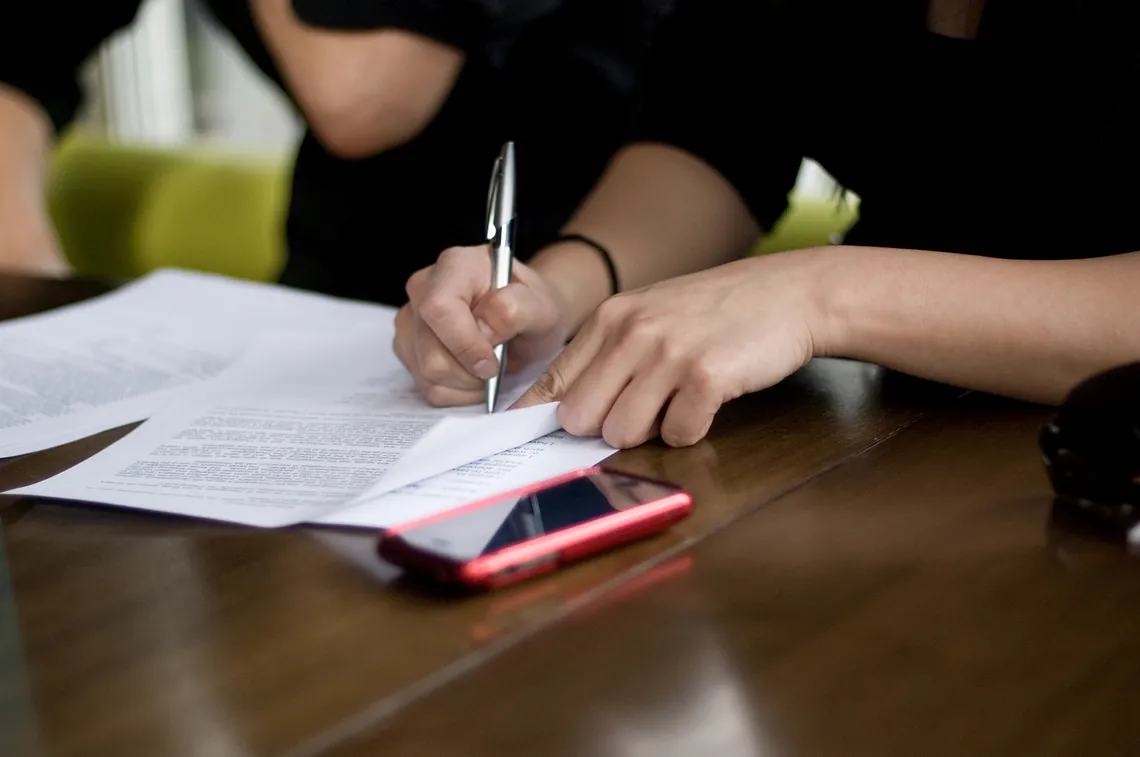 Two people signing a legal document